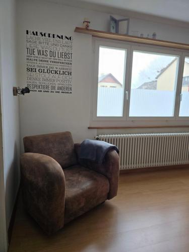 a brown chair in a room with a window at steinlisonne in Möhlin