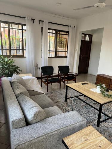a living room with a couch and a table at 27 Artful Tegeta holiday home with Inverter in Dar es Salaam