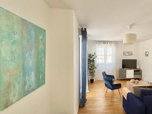 een woonkamer met een groot schilderij aan de muur bij Modern Apartment Near Disneyland Paris in Serris