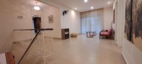 a hallway with a staircase and a living room at W&P Lakeside Homestay Sri Gading in Sri Gading