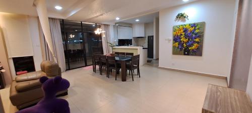 a living room with a table and a dining room at W&P Lakeside Homestay Sri Gading in Sri Gading