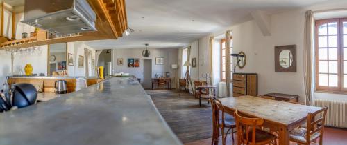une cuisine avec une table et des chaises dans une pièce dans l'établissement Ecuries du Château de Saint-Fargeau, à Saint-Fargeau