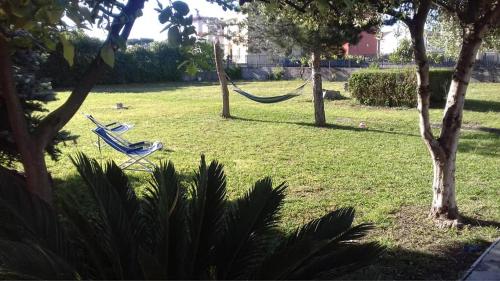 two lawn chairs in a yard with a hammock at Villa Elena in Minturno