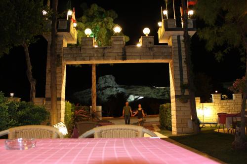 a man and woman walking under a stone bridge at night at Hotel HAL-TUR in Pamukkale