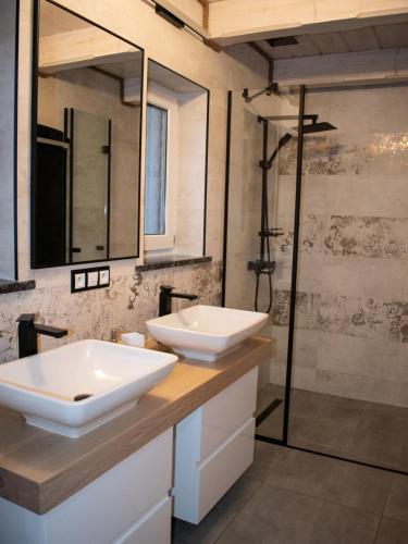 a bathroom with two sinks and a shower at Domek U Babci in Istebna