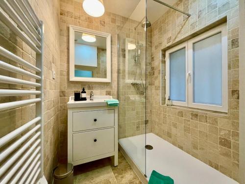 une salle de bain avec un lavabo et une douche dans l'établissement La Chouette Blanche, hypercentre, à Dijon