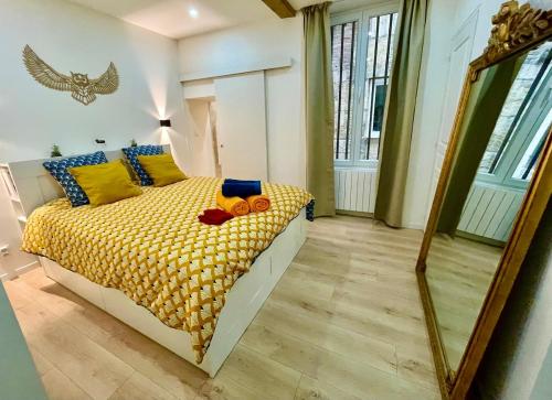 - une chambre avec un lit doté d'oreillers jaunes et bleus dans l'établissement La Chouette Blanche, hypercentre, à Dijon