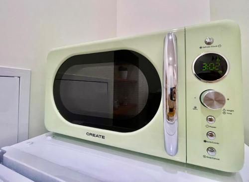un four micro-ondes vert assis au-dessus d'un comptoir dans l'établissement La Chouette Blanche, hypercentre, à Dijon