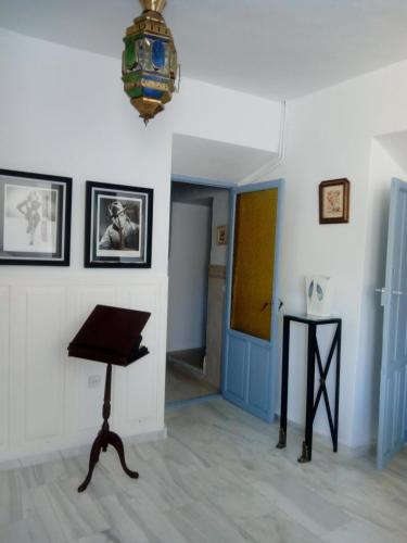 a room with a piano and a blue door at Casa de Comedias in Almagro