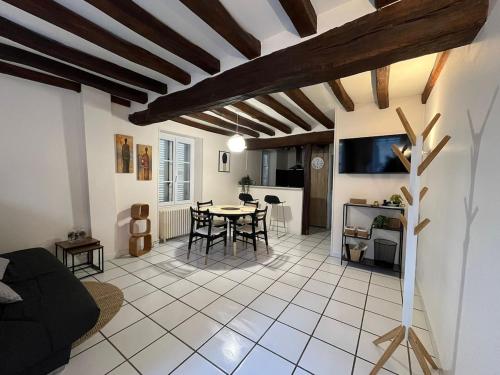 un salon avec une table et une cuisine dans l'établissement Maison de la Fontaine, à Champs