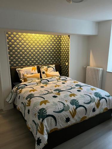 une chambre avec un lit avec un couvre-lit fleuri dans l'établissement Maison de la Fontaine, à Champs