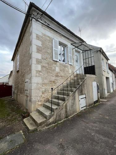 - un bâtiment en briques avec des escaliers sur son côté dans l'établissement Maison de la Fontaine, à Champs