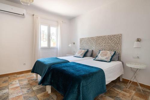 a bedroom with two beds with blue sheets and a window at Sweet House in Islas Baleares