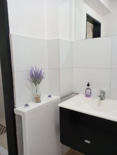 a white bathroom with a sink and a mirror at Estudio in San Pedro