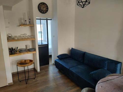 un salon avec un canapé bleu et une table dans l'établissement Atypical apartment with a poudlard air, à Mont-Dol