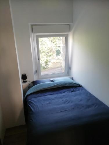 une petite chambre avec un lit et une fenêtre dans l'établissement Atypical apartment with a poudlard air, à Mont-Dol