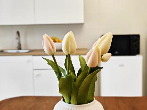 a vase with pink and white flowers in a kitchen at b&b il Melograno in Berlingo