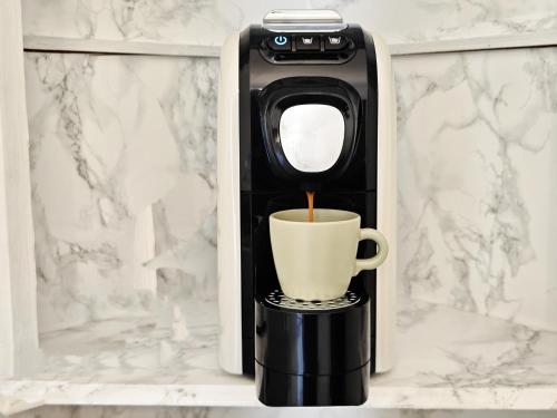 a coffee maker with a cup on a shelf at b&b il Melograno in Berlingo