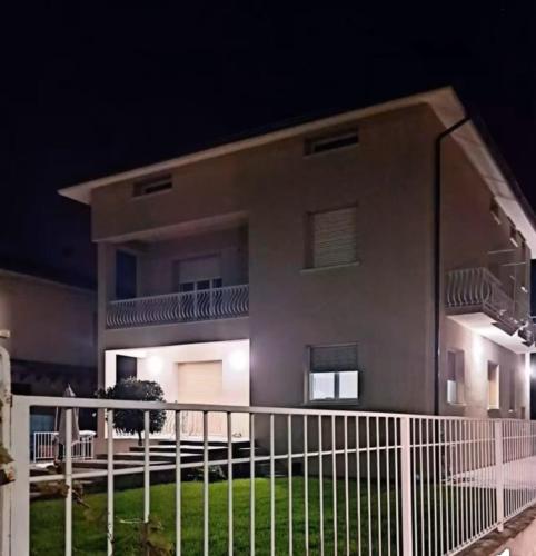 a building with a fence in front of it at night at b&b il Melograno in Berlingo
