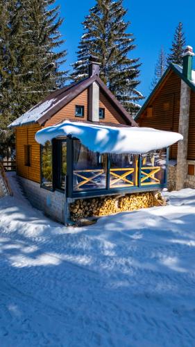 a cabin in the snow with a snowboard at Black Lake Chalet in Žabljak