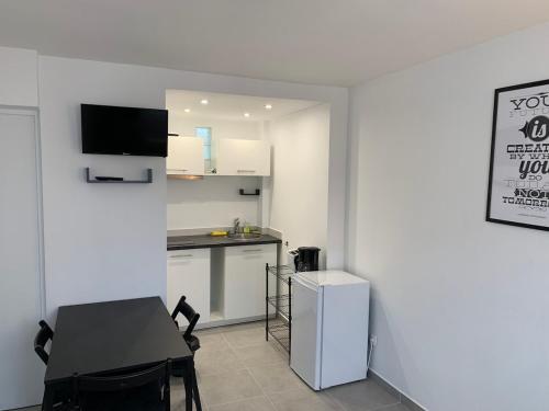 une petite cuisine avec une table et un réfrigérateur dans l'établissement Appartement idéale proche Paris, à Arnouville-lès-Gonesse