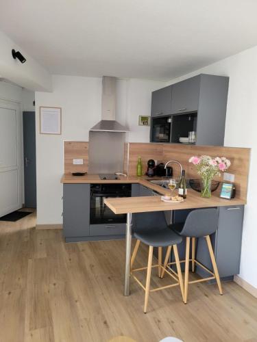 - une cuisine avec une table en bois et un comptoir dans l'établissement Appart cosy avec terrasse et parking privé, à Guidel