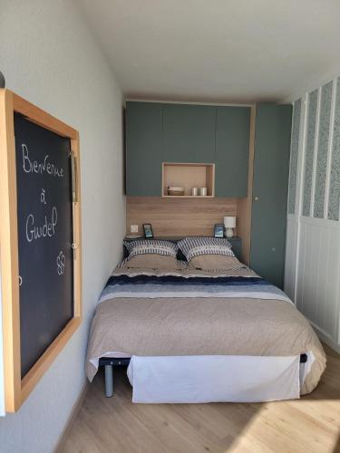 - une chambre dotée d'un lit avec un tableau noir sur le mur dans l'établissement Appart cosy avec terrasse et parking privé, à Guidel