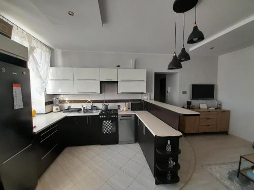a large kitchen with white cabinets and a sink at Na Starówce in Lidzbark