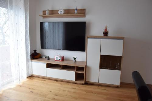 セニにあるApartment NIKIの壁に薄型テレビが取り付けられたリビングルーム