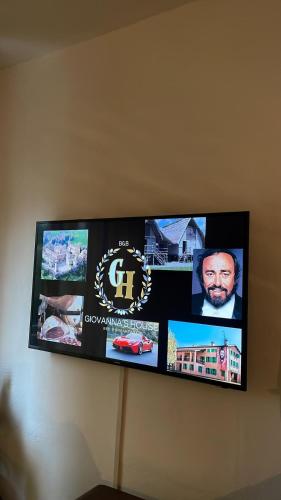 a tv on a wall with pictures on it at Giovanna's House in Montale