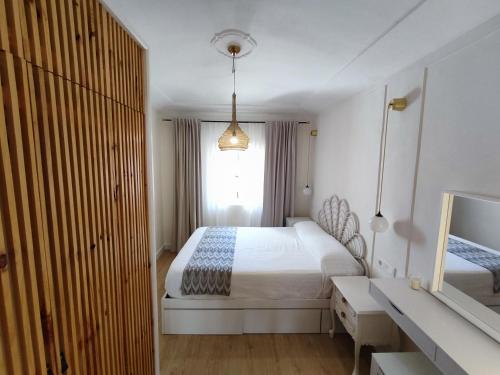 een slaapkamer met een bed, een bureau en een raam bij River House in Cáceres