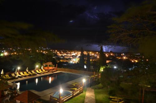 a pool with a view of a city at night at Montecassino in Capilla del Monte