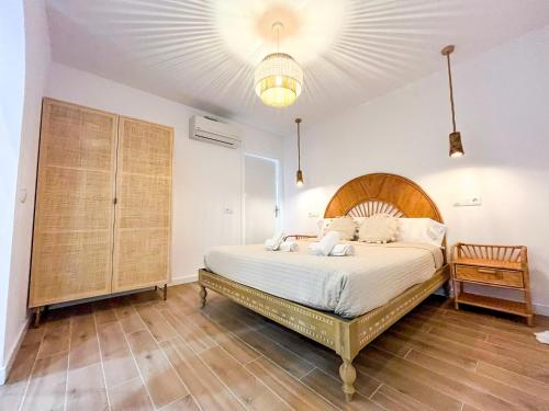 a bedroom with a large bed with a wooden headboard at Chakra House Fuerteventura - Affordable Rooms in a Cozy Guesthouse in Corralejo