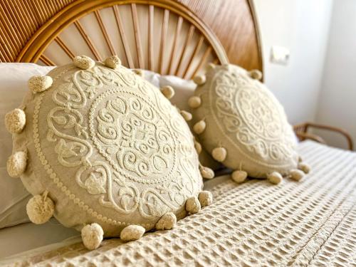 a bed with two pillows on top of it at Chakra House Fuerteventura - Affordable Rooms in a Cozy Guesthouse in Corralejo