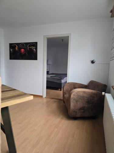 a living room with a chair and a bedroom at steinlisonne in Möhlin