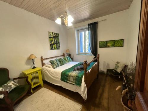 une chambre avec un lit, une chaise et une fenêtre dans l'établissement L'Ancienne Forge, à Villarzel-du-Razès