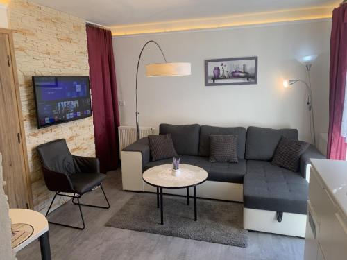 a living room with a couch and a table at Květinové apartmány Horní Planá in Horní Planá