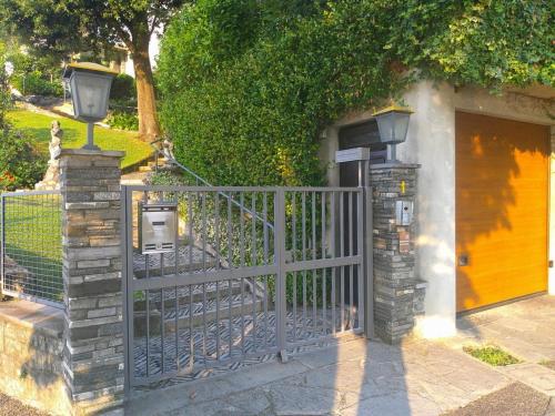 a gate with two lights on it next to a building at Lakeviewcabin - King Room With Balcony in Como