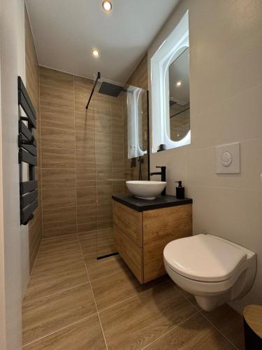 a bathroom with a white toilet and a sink at CentraLuxury in Piatra Neamţ