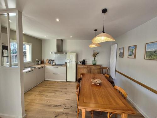 a kitchen with a wooden table and a dining room at Le gîte de Midi for 6 pers - Quiet garden in Uzein