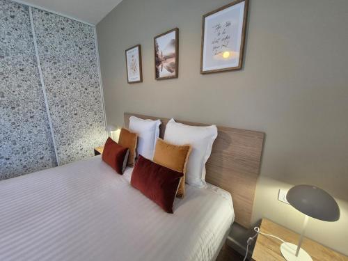 a bedroom with a bed with four pillows at Le gîte de Midi for 6 pers - Quiet garden in Uzein