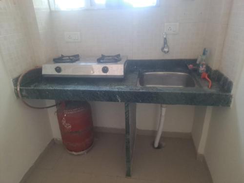 a kitchen counter with a sink in a room at Central Park, GOLD VALLEY in Jalgaon