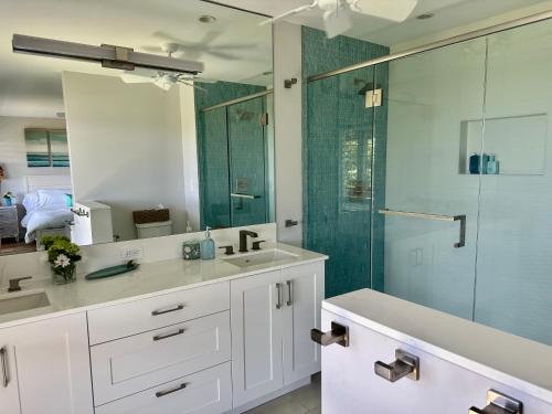a bathroom with a sink and a glass shower at Ocean Views from Every Room 3BD 3BA in Lahaina