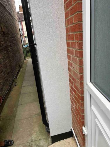 an open door of a building with a brick wall at Studio flat with private entrance in Lewisham