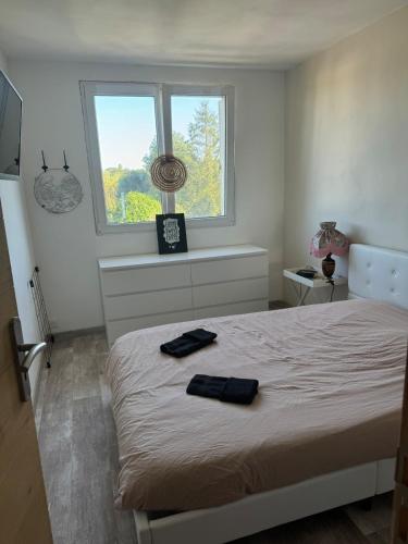 une chambre avec un lit avec deux serviettes dessus dans l'établissement Quiet modern apartment & near city center, à Rousies
