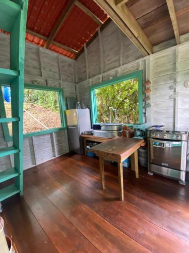a kitchen with a wooden table in a room at Gracias Madre Jungle and Ocean View Cabins in Bocas del Toro