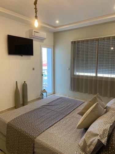 a bedroom with a bed and a flat screen tv at appartement à oujda in Oujda