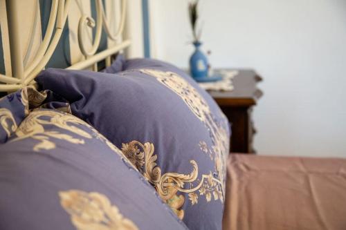a couch with blue and gold pillows on it at Filocase - What a view! in SantʼAgata deʼ Goti