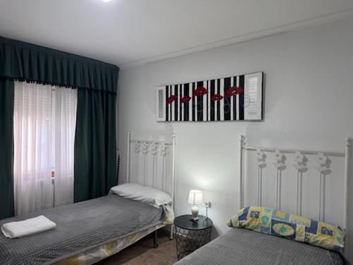 Un dormitorio con dos camas individuales en una habitación. en Pensión Portus Marini, en Portomarín