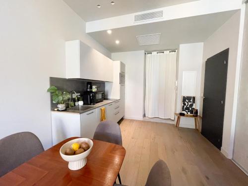 une cuisine et une salle à manger avec une table et des chaises en bois dans l'établissement Appartement cozy au coeur de Nice, à Nice
